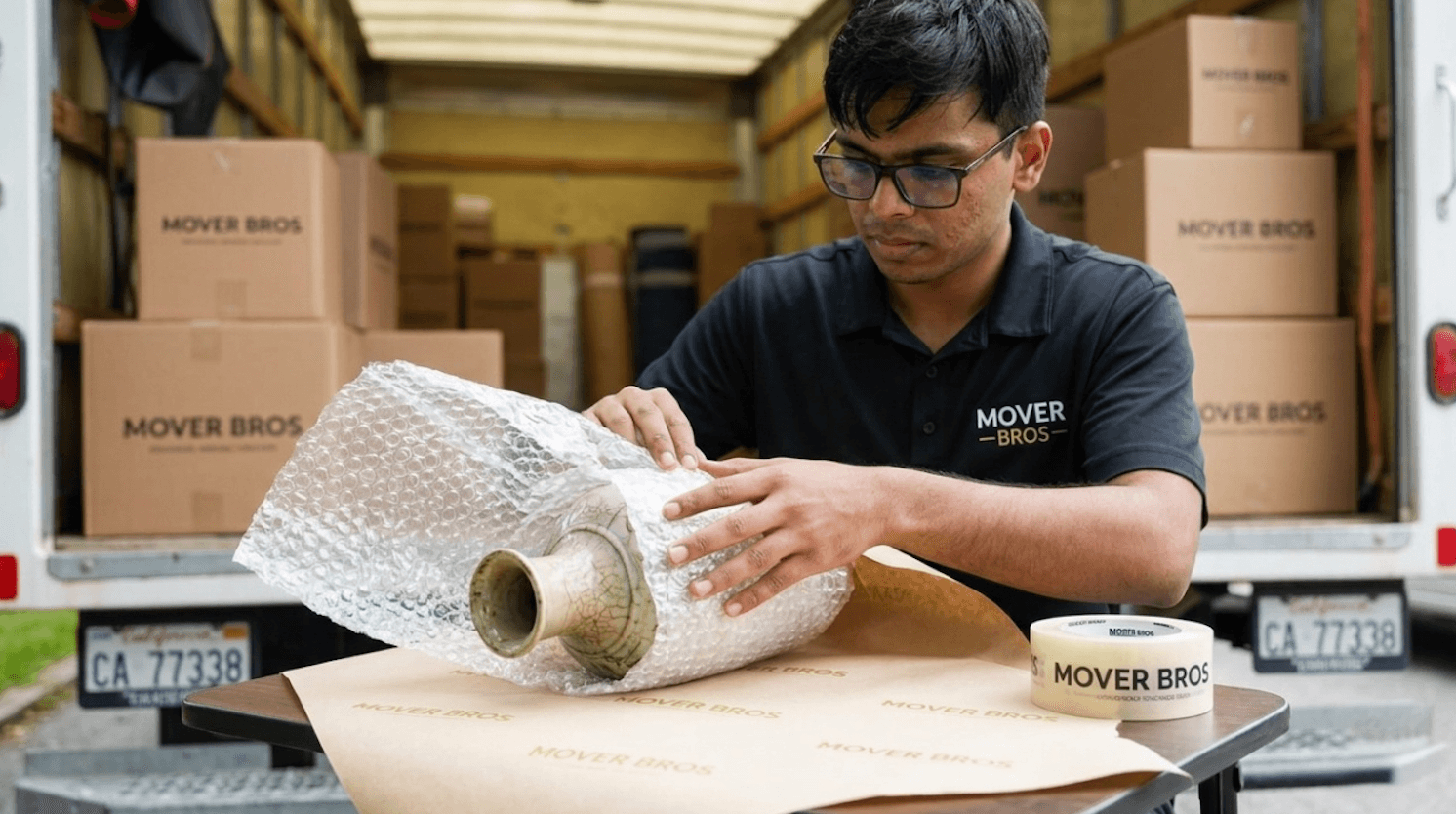 Mover Bros team member carefully wrapping fragile items with bubble wrap